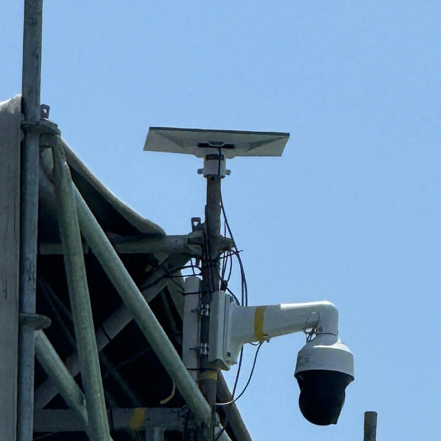Cámara PTZ instalada en torre junto a antena de transmisión en un evento